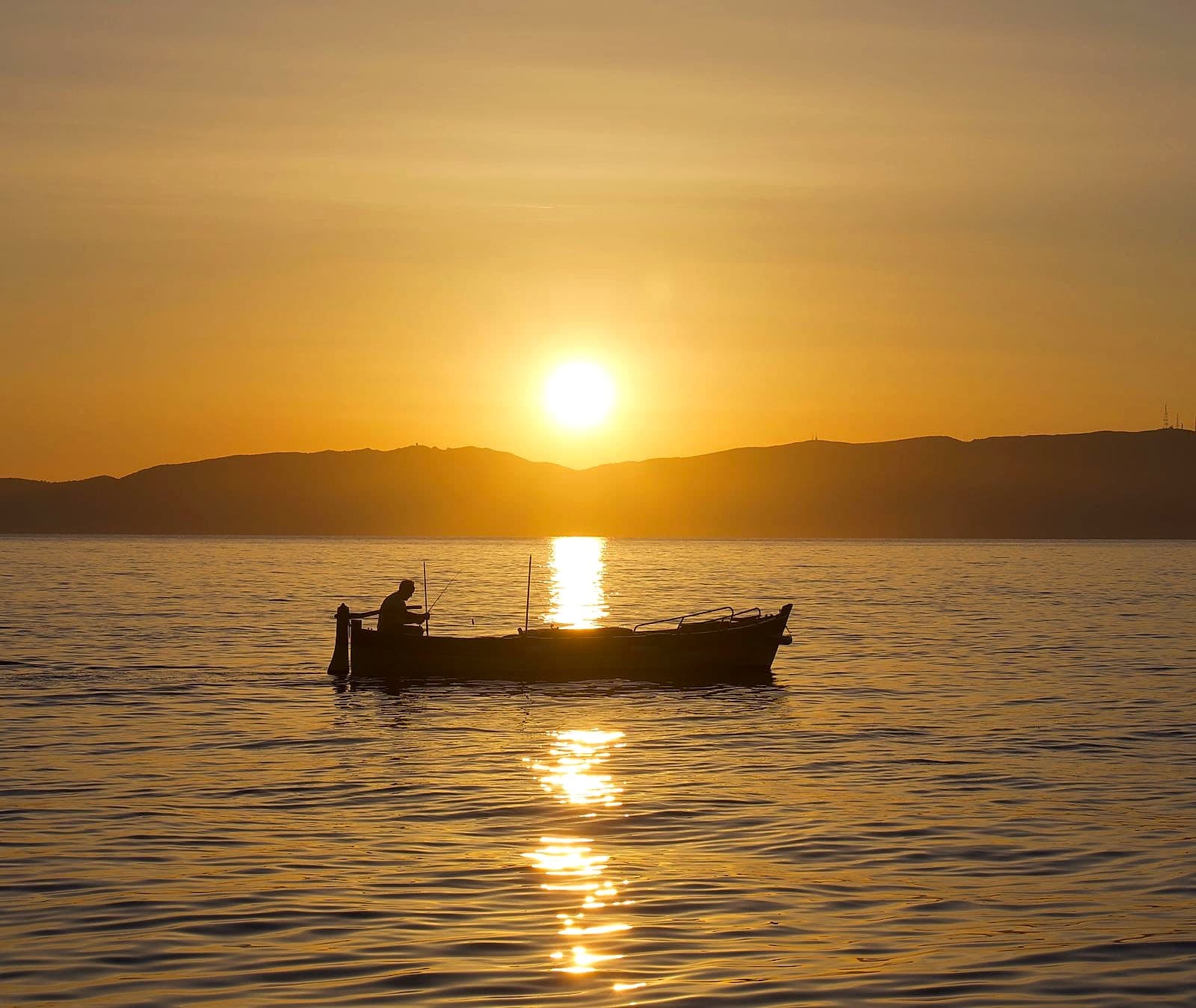Tramonto dorato sul mare, rientro in barca al calar del sole